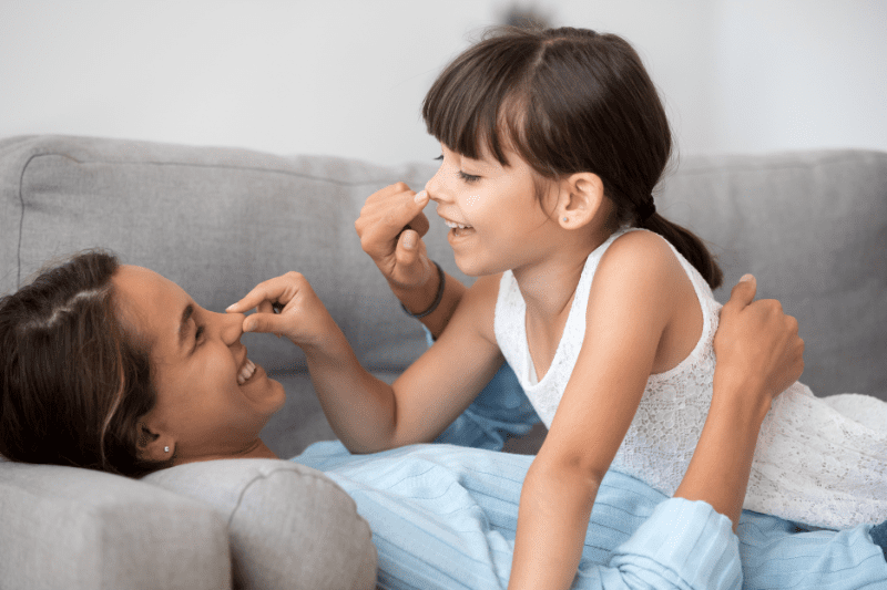 5-year-old child practising listening skills by playing Simon Says with a parent for school readiness.