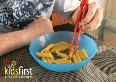 A child eating pasta with chopsticks