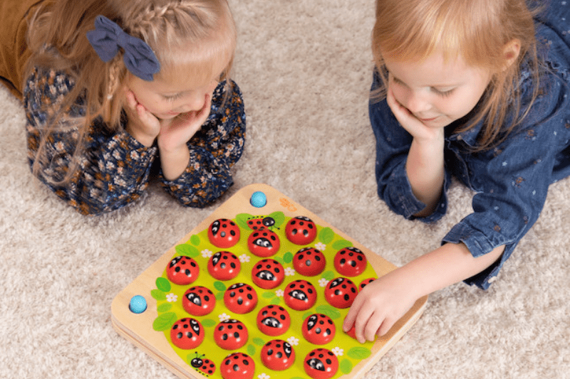 4-year-old child and friends playing "The Game of Ladybirds" to develop social communication skills.