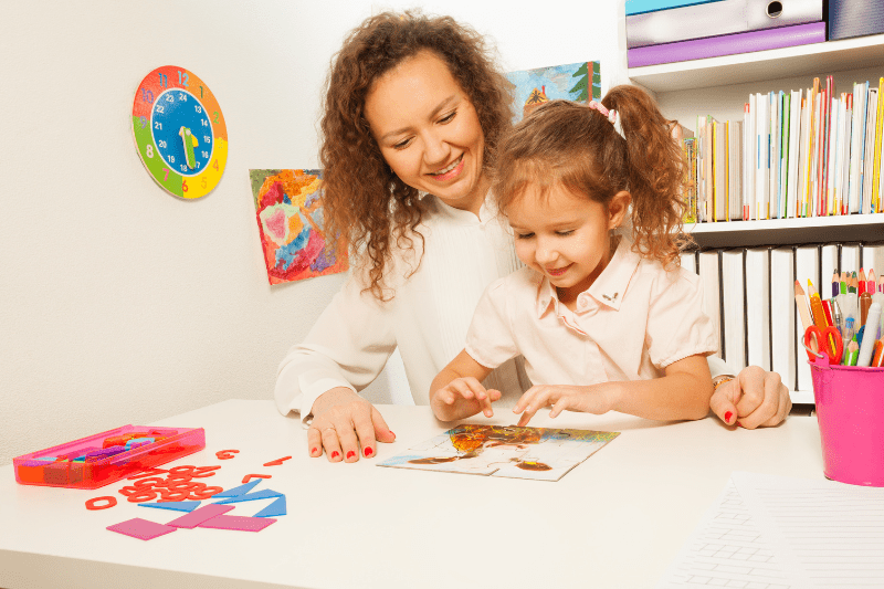 Child with developmental delay receiving Early Intervention support, celebrating achievement of completing a puzzle