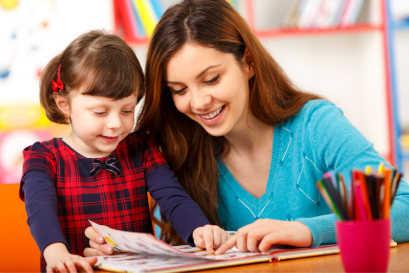 Child practicing speech therapy with therapist at home.