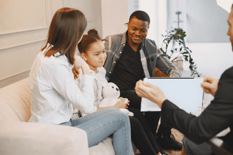 Speech therapist teaching a child and parent how to use communication tools during speech therapy in Northern Beaches, Sydney.