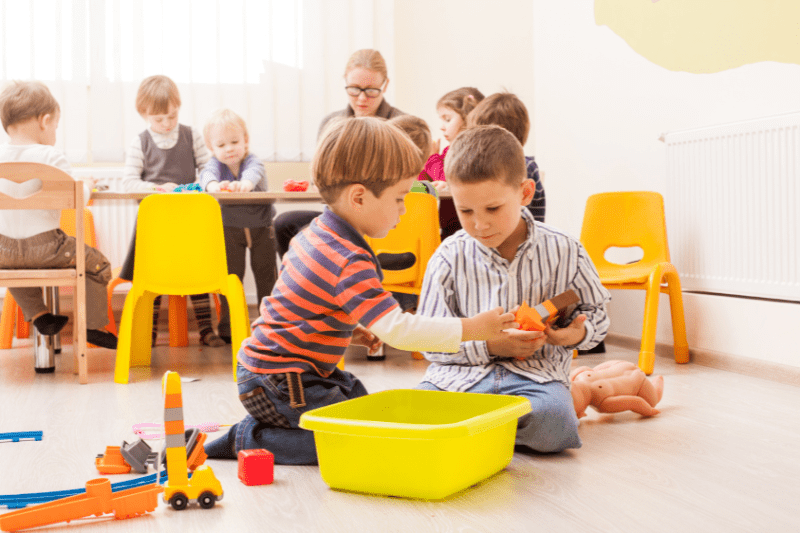 Child having difficulty sharing toys with another child during playtime, indicating social immaturity.