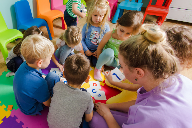 Children participating in a group activity with an Early Intervention Specialist from Kids First Children's Services, promoting social skills and preschool participation.