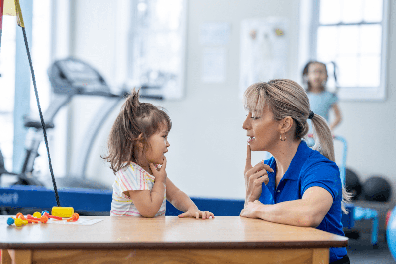 Happy child talking with a friendly speech therapist at Kids First Children's Services on Sydney's northern beaches.