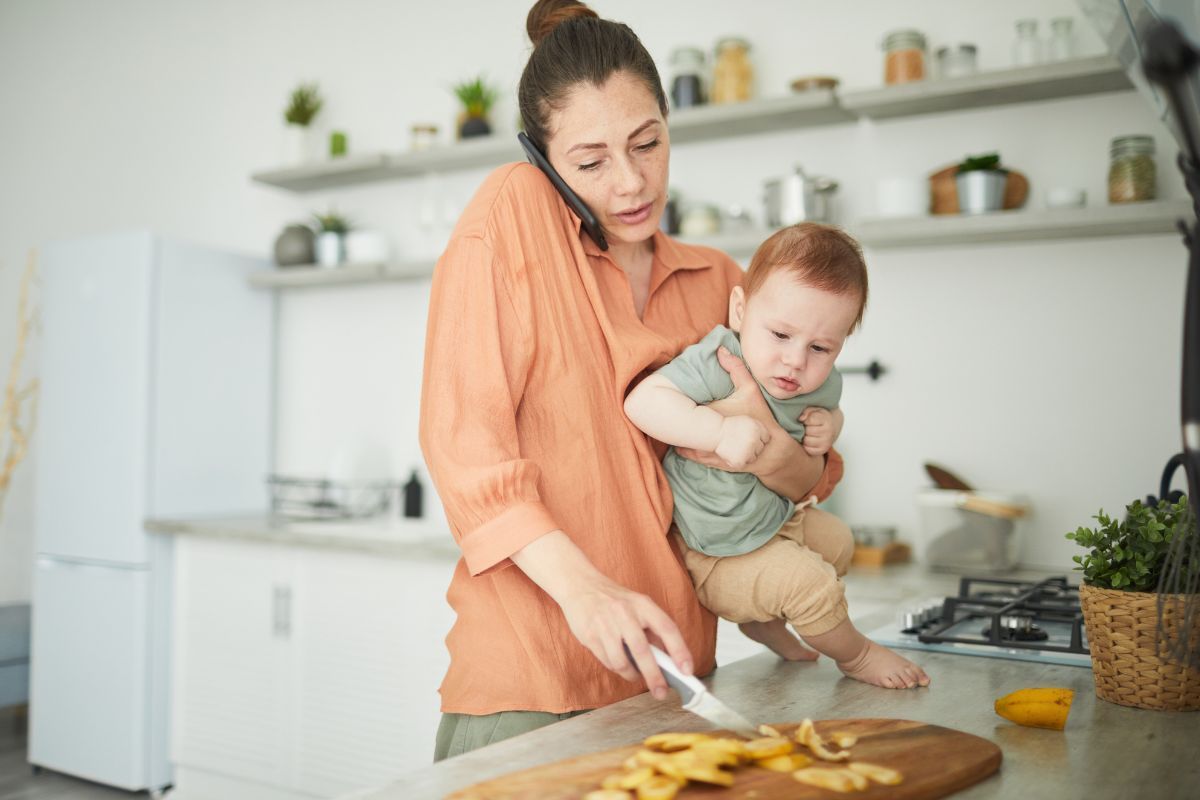 Northern Beaches parent taking an unexpected NDIS check-in call at home while caring for a baby, Kids First Children’s Services