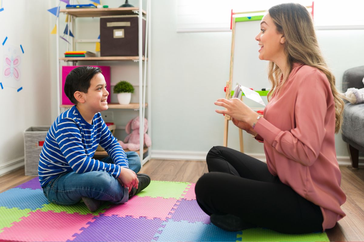 Speech pathologist working with a school-aged child during a speech therapy session at Kids First Children’s Services in Brookvale, with Medicare rebates available for eligible children.